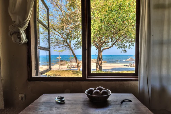 Vista através de uma janela de uma casa na praia Fotografia De Stock