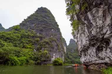 Ninh Binh, turistler Tam Coc Ulusal Parkı 'nın mağara turu sırasında tekneyle nehirde yüzerler. Trang An, Vietnam, Asya