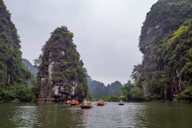 Ninh Binh, turistler Tam Coc Ulusal Parkı 'nın mağara turu sırasında tekneyle nehirde yüzerler. Trang An, Vietnam, Asya