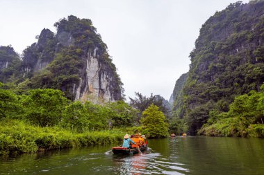 Ninh Binh, turistler Tam Coc Ulusal Parkı 'nın mağara turu sırasında tekneyle nehirde yüzerler. Trang An, Vietnam, Asya