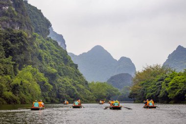 Ninh Binh, turistler Tam Coc Ulusal Parkı 'nın mağara turu sırasında tekneyle nehirde yüzerler. Trang An, Vietnam, Asya