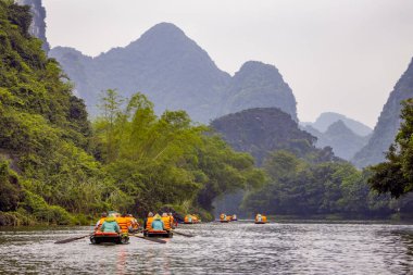 Ninh Binh, turistler Tam Coc Ulusal Parkı 'nın mağara turu sırasında tekneyle nehirde yüzerler. Trang An, Vietnam, Asya