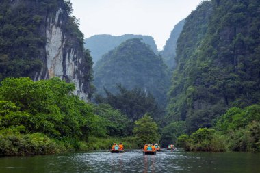 Ninh Binh, turistler Tam Coc Ulusal Parkı 'nın mağara turu sırasında tekneyle nehirde yüzerler. Trang An, Vietnam, Asya