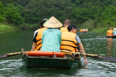 Ninh Binh, turistler Tam Coc Ulusal Parkı 'nın mağara turu sırasında tekneyle nehirde yüzerler. Trang An, Vietnam, Asya