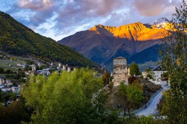 Tipik kule evleri olan Mestia köyünün günbatımı manzarası. Yukarı Svaneti, Georgia. Arkaplanda altın dağlar