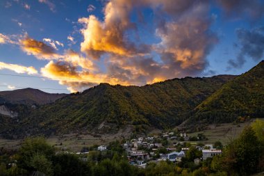 Tipik kule evleri olan Mestia köyünün günbatımı manzarası. Yukarı Svaneti, Georgia. Arkaplanda altın dağlar