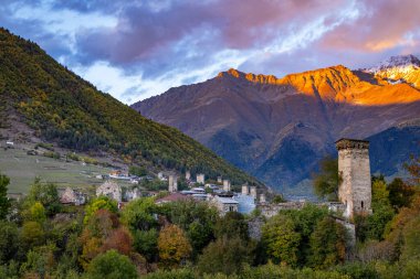 Tipik kule evleri olan Mestia köyünün günbatımı manzarası. Yukarı Svaneti, Georgia. Arkaplanda altın dağlar