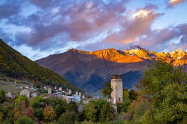 Tipik kule evleri olan Mestia köyünün günbatımı manzarası. Yukarı Svaneti, Georgia. Arkaplanda altın dağlar