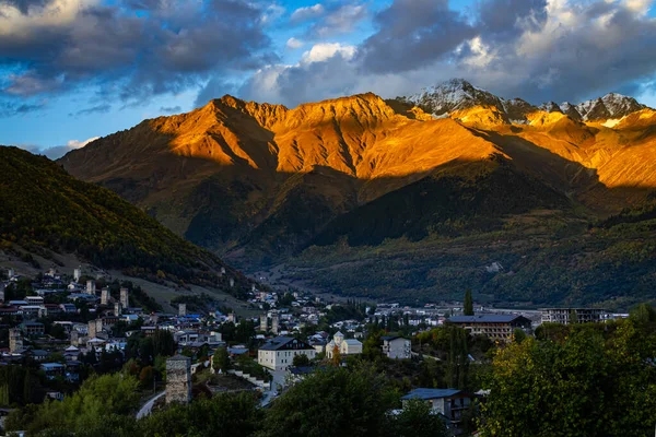 Tipik kule evleri olan Mestia köyünün günbatımı manzarası. Yukarı Svaneti, Georgia. Arkaplanda altın dağlar