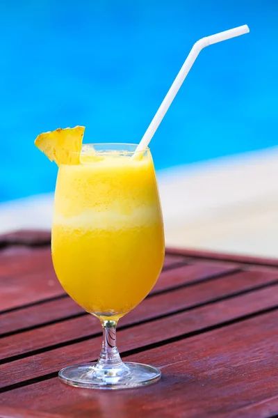 Cóctel de jugo de piña fresca cerca de la piscina Imagen de stock