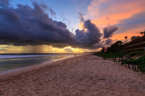 Mer et plage avec de sombres nuages de pluie au coucher du soleil — Photo