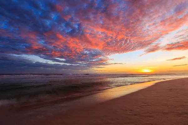 Lindas nuvens coloridas na praia ao pôr do sol Fotografia De Stock