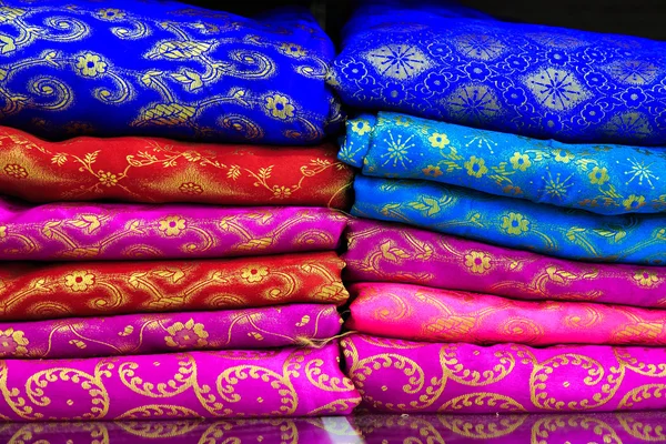 Pilha de tecidos coloridos nas prateleiras — Fotografia de Stock