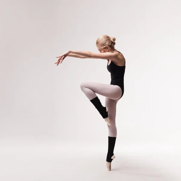 Балерина в черном наряде позирует на пальцах ног — стоковое фото