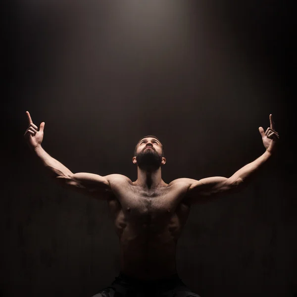 어두운 스튜디오 배경 기도 하는 남자 — 스톡 사진