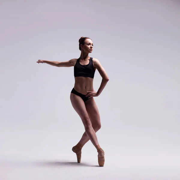 Hermosa bailarina de ballet posando en puntas. Fotos De Stock