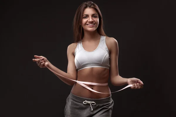 Sportovní žena měřící páskou — Stock fotografie