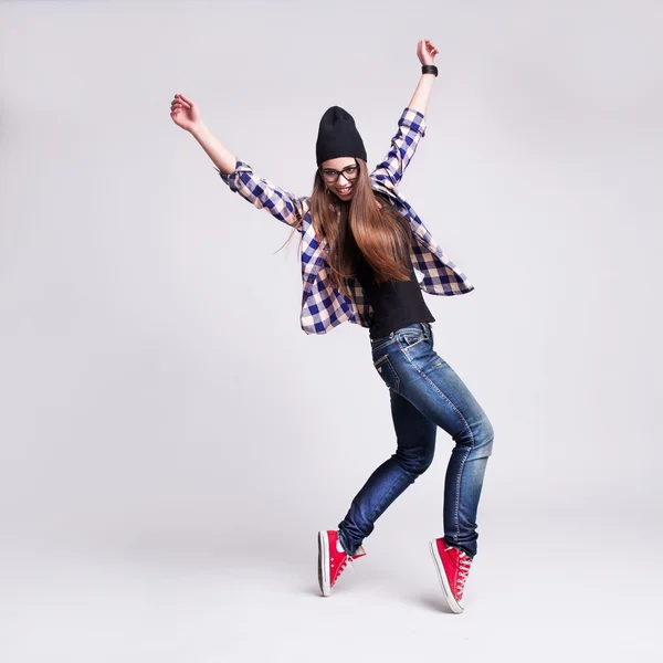 Dancing hipster flicka i glasögon och svart mössa — Stockfoto