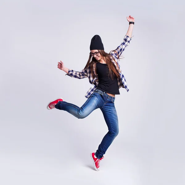 Dancing hipster flicka i glasögon och svart mössa — Stockfoto