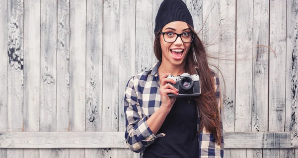 Fille souriante dans des lunettes avec caméra vintage — Photo