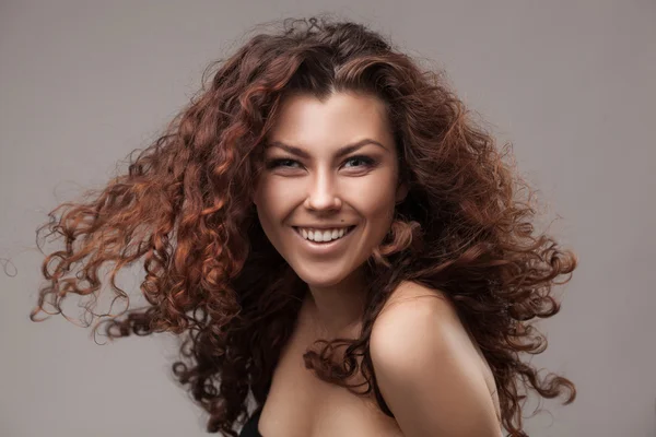 Mulher sorridente com cabelo encaracolado marrom saudável — Fotografia de Stock