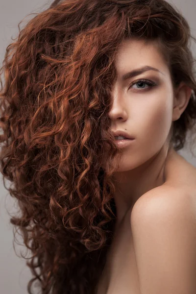 Žena s zdravé hnědé kudrnaté vlasy — Stock fotografie