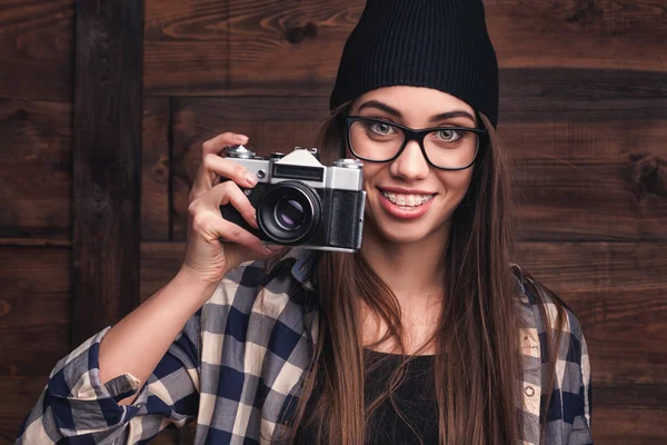 Κορίτσι σε γυαλιά και τιράντες με εκλεκτής ποιότητας φωτογραφική μηχανή — Φωτογραφία Αρχείου