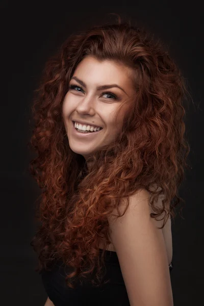 Lächelnde Frau mit gesundem braunem lockigem Haar — Stockfoto