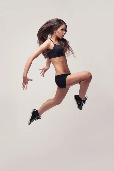 Молодая женщина делает гимнастический прыжок — стоковое фото