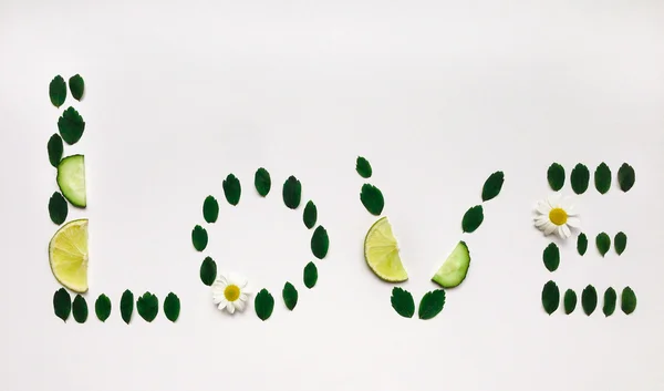 Word "love" made of lime and flowers on white background. Flat lay — Stock Photo, Image