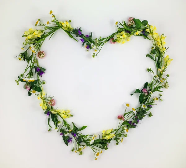 Símbolo do coração feito de flores e folhas no fundo branco — Fotografia de Stock