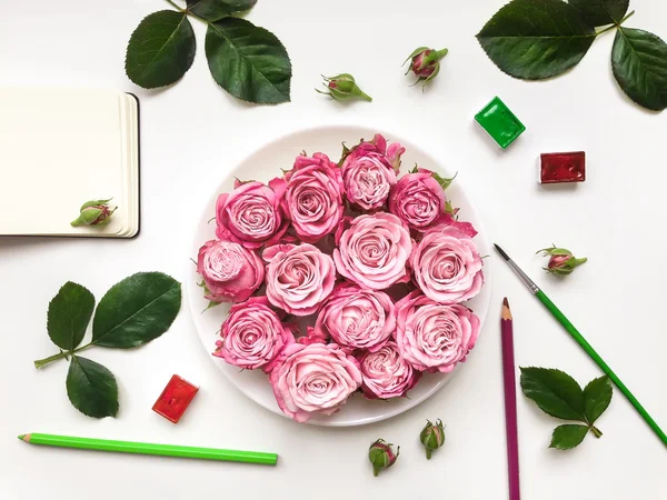 Composição colorida com rosas, caderno de esboços e acessórios. Depósito plano — Fotografia de Stock