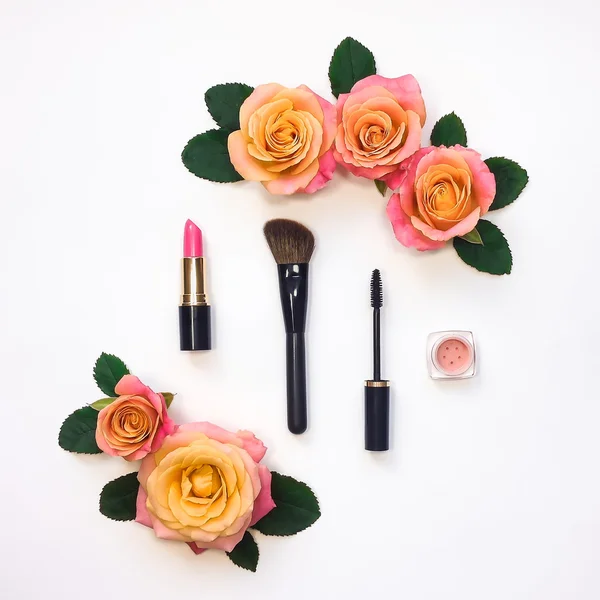 Decorative flat lay composition with cosmetics and flowers. Flat lay, top view