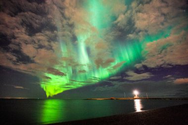 Reflection of the northern lights in the ocean clipart