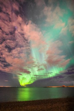 Reflection of the northern lights in the ocean clipart
