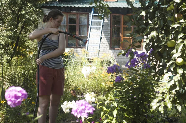 Девушка поливает растения — стоковое фото