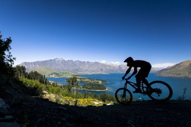 Silhouette of mountain bike rider in Queenstown, New Zealand clipart