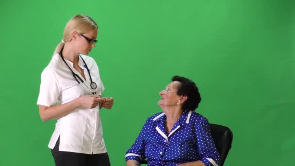 Nurse talking to sitting old lady. — Stock Video