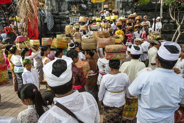 Балийцы с подношениями входят в храм Бат-пещеры Гуа-Лава на Бали - Индонезия - Азия — стоковое фото