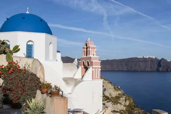 Eine kleine weiße griechisch-orthodoxe Kirche mit einem typischen blauen Dach auf der Klippe in oia (ia), Santorini Insel, Kykladen Griechenland — Stockfoto