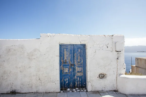 Blauwe deur in een witte muur - Oia - Santorini - Griekenland — Stockfoto