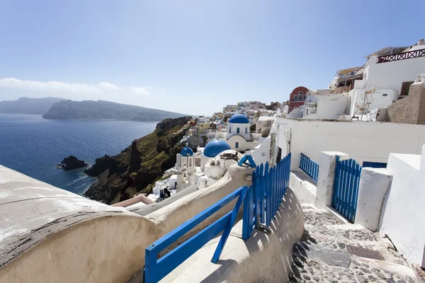 A small white Greek Orthodox church with a typical blue roof on the cliff in Oia (Ia), Santorini island, Cyclades Greece — Stock Photo, Image