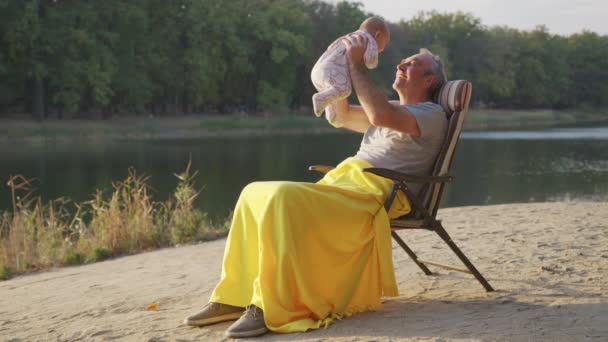Grootvader Holding pasgeboren baby kleindochter buiten. — Stockvideo