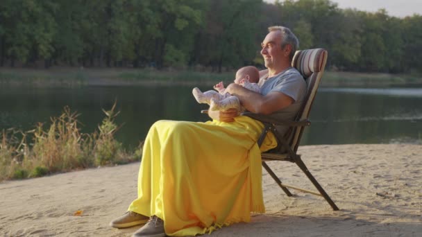 Dědeček drží novorozeně dítě vnučka venku. — Stock video