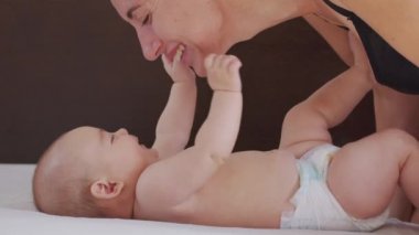 Genç annenin yakın plan çekimi, yeni doğmuş bebeğiyle bir sabah kreşte oynayacak. Çocuk, bebek, ebeveynlik, çocukluk, hayat, annelik kavramı.
