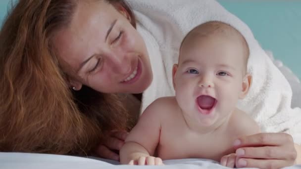 Close up tiro de jovem mãe está brincando com seu bebê recém-nascido em um berçário em uma manhã. Conceito de filhos, bebê, paternidade, infância, vida, maternidade, maternidade. — Vídeo de Stock