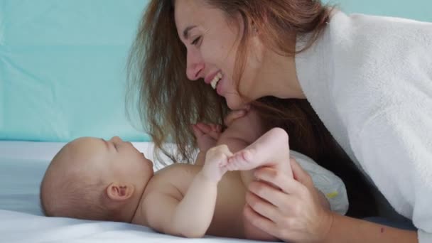 Närbild mamma försiktigt kyssa barnet njuter av kärleksfull mamma lekfullt ta hand om småbarn hemma dela anslutning med sitt nyfödda barn. hälsosam barnomsorg. — Stockvideo