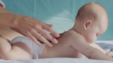 Anne, küçük çocuğuna masaj yapıyor. Yakın çekim..