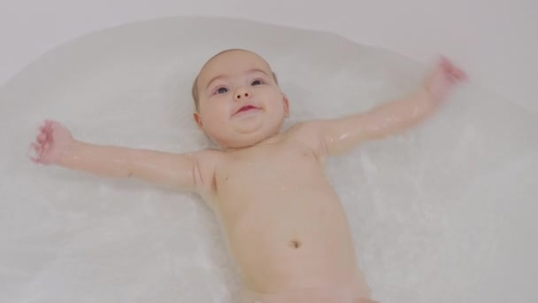 Feliz niño juguetón se baña en el baño. — Vídeos de Stock