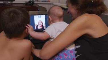 Anne ve yeni doğmuş bebeği ve oğlu video görüşmesi yapıyor. Teknoloji kavramı, yeni nesil, aile, bağlantı, ebeveynlik.